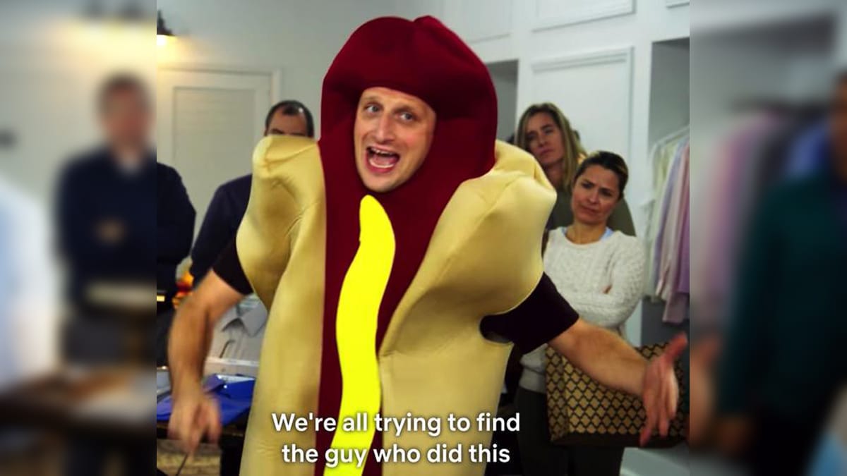 Still from the Hot Dog Car sketch featuring a person in a hot dog costume with the subtitle "We're all trying to find the guy who did this".