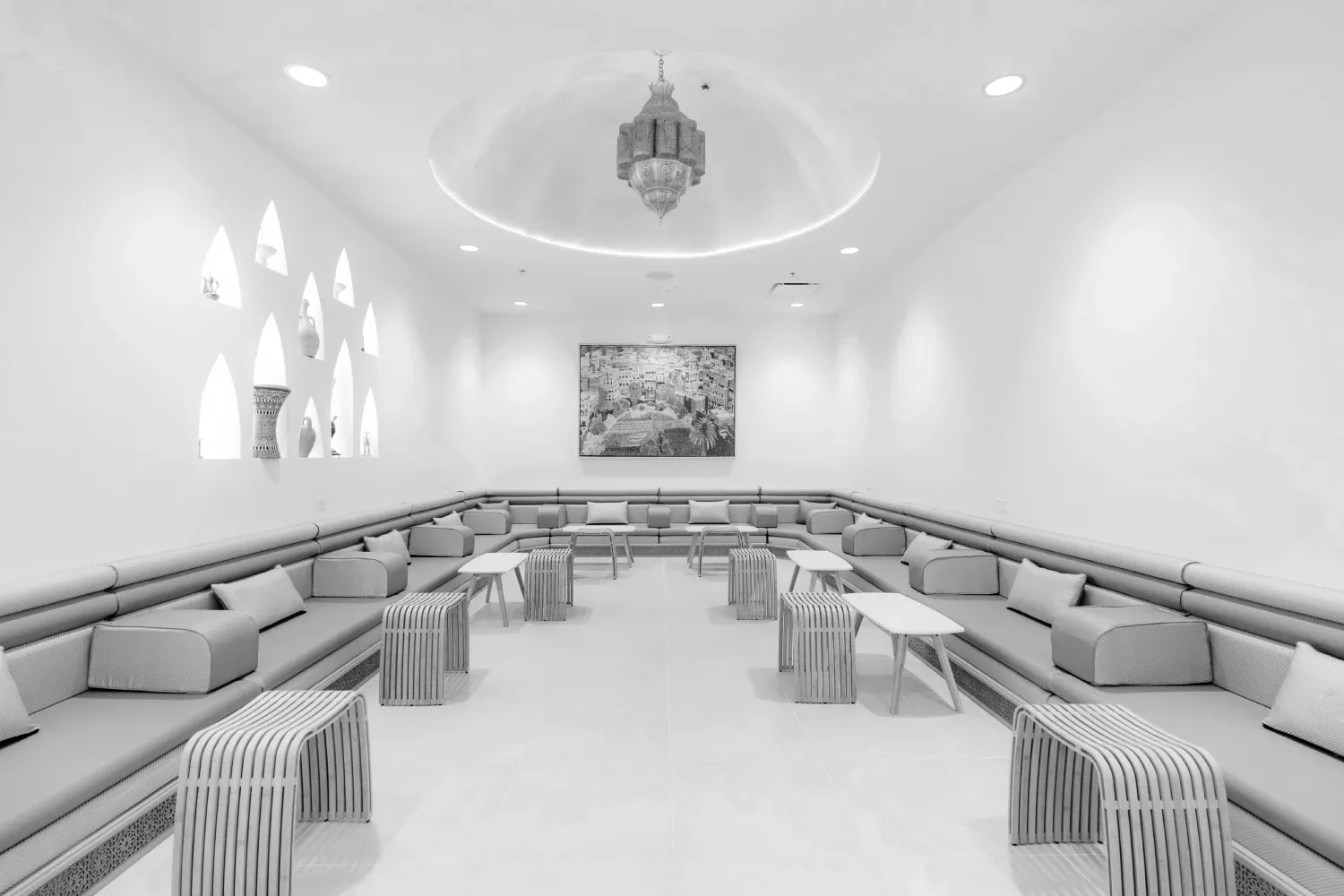 A wooden tray holding a latte in a white cup with a camel design on the foam, next to coffee and spices