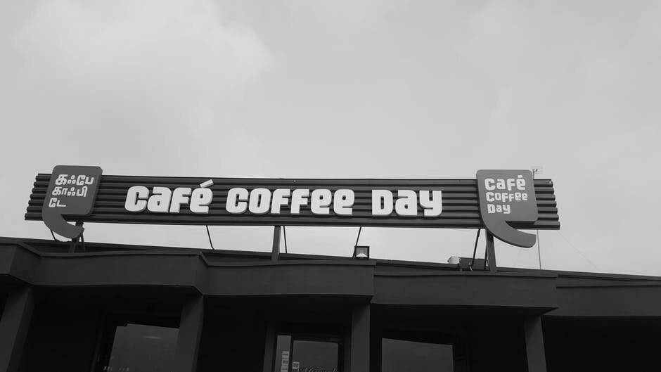 A sign for Cafe Coffee Day on top of a building